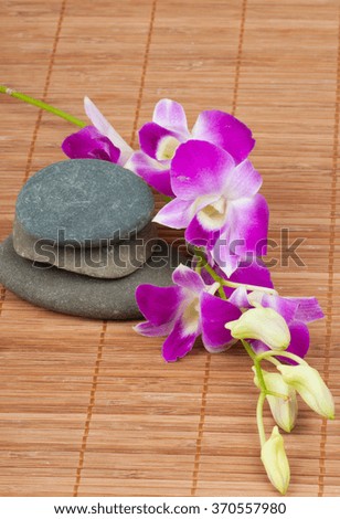 Orchid and spa-stones on wooden background
