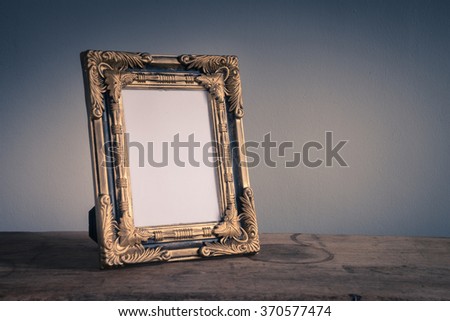 Vintage photo frame on wooden table over grunge background