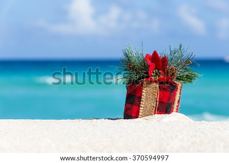 Tropical celebration on beach. Present box on sand against turquoise caribbean sea water