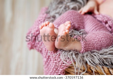 Close up picture of new born baby feet on a pink plaid