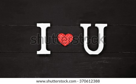 Wooden letters word I LOVE YOU on black wooden background