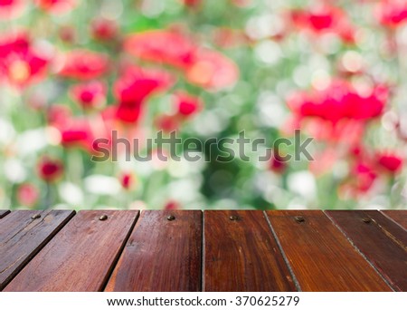 Look out from the wooden table,Blur image of Colorful chrysanthemums as background.
