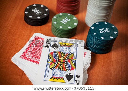 Poker chips and generic playing cards. Courts for poker chips and dice on wooden table