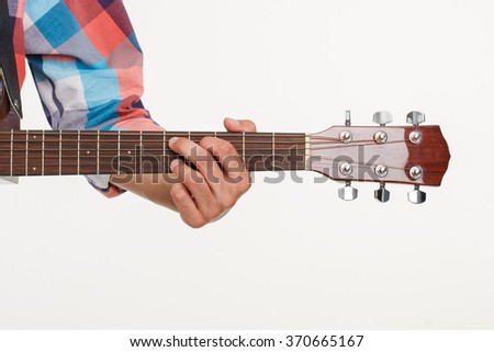 Fingerboard of guitar and hand playing guitar. Man's hand holding fingerboard. Picture of fingerboard on white background.