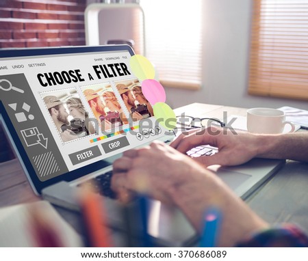 Smartphone app menu against cropped image of graphic designer working on laptop