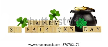 Happy St Patricks Day wooden blocks with Pot of Gold and shamrocks over white