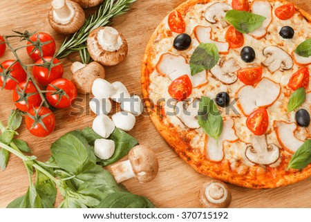 Pizza with mushrooms, olives and tomatoes. Basil, rosemary and fresh vegetables. Freshly homemade 