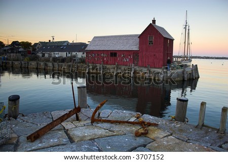 Most photographed famous fishing shack in Bearskin Neck Wharf in New England on the background with antique anchors on the foreground.
