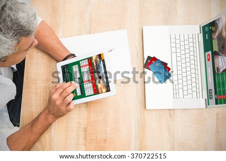Colorful world credit cards against casual businessman using blank screen tablet