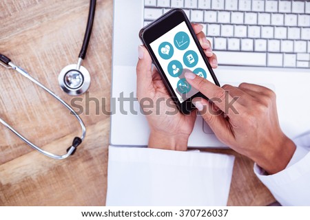 Medical app against doctor using smartphone on wooden desk