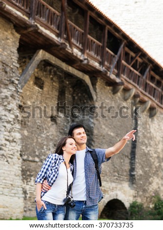 Young couple being tourists exploring the medieval buildings,