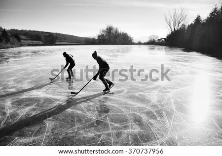 Two hockey players during ice hockey game on natural ice