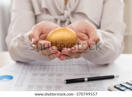 Funds manager offer golden egg to investor and the report analyzes the return on the stock market, calculator on desk. Concept of growth investment portfolio.