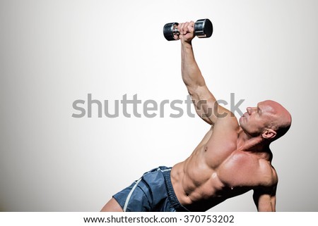 Man exercising with dumbbells against grey vignette