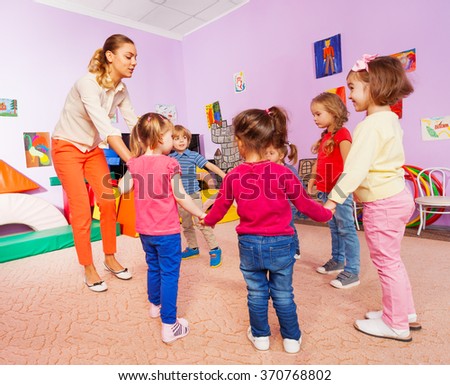 Little children and teacher roundelay on lesson Royalty-Free Stock Photo #370768802