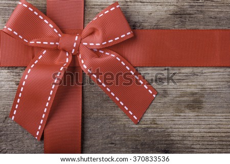 red gift ribbon on wooden background closeup