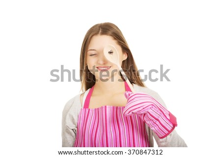 Happy teen woman wearing kitchen apron.