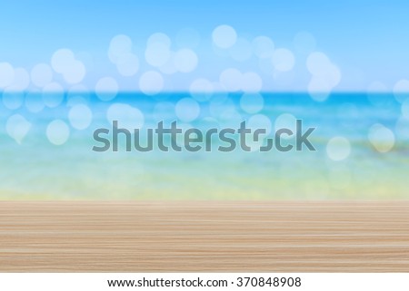 Wood table top on blurred beach background with bokeh - can be used for display or montage your products