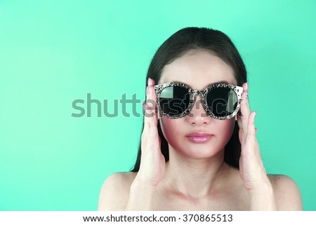 Picture of beautiful retro-styled woman in sunglasses on green background, Pop art portrait.