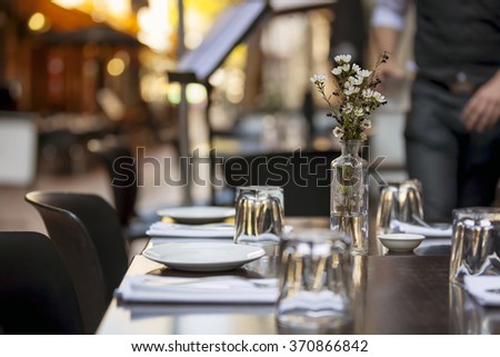 Cafe table in laneway.  Focus on Flowers.   Royalty-Free Stock Photo #370866842