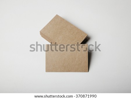 Stack of empty craft business cards on white background with soft shadows. 