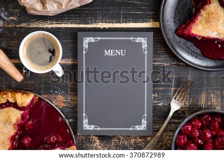 Baking background with sliced cherry pie, flour, rolling pin and menu chalkboard on the black wooden table. Ingredients for baking/dessert or pie making Royalty-Free Stock Photo #370872989