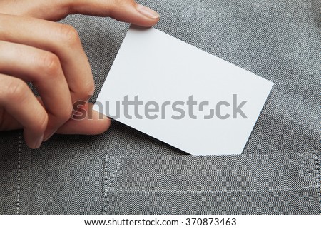 Man putting blank business card in his pocket of shirt.
