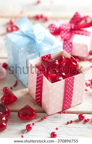 Red hearts and colored gift boxes on wooden background