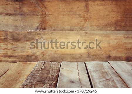 Grunge vintage wooden board table in front of old wooden background. Ready for product display montages 