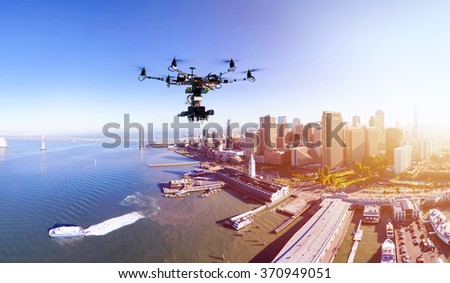 Professional photography drone with the cinema camera flying over San-Francisco pears and the financial district at the summer sunset. Remote control photography innovations concept.