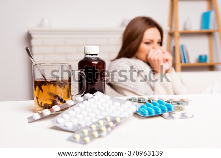 close up photo  of cup of tea, pills and mixture. sick woman's treated Royalty-Free Stock Photo #370963139