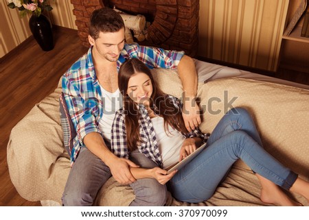 Top view photo of happy lovely couple  sitting on the sofa with tablet