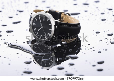 Watches with water drops on a white acrylic background, studio lighting