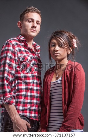 Mixed race couple look at the camera in studio environment