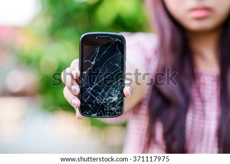 Girl hand holding cracked mobile smartphone