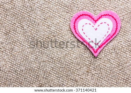 Pink heart shape made with cotton on linen fabric. Valentine background.