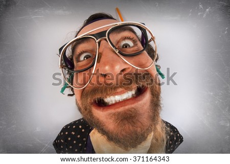 Bearded crazy person lunatic wearing several pairs of glasses Royalty-Free Stock Photo #371164343