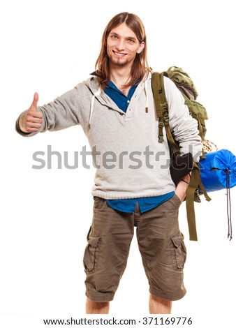 Portrait of man tourist backpacker on trip showing thumb up gesture. Young guy hiker backpacking. Summer vacation travel. Studio shot. Isolated on white background.