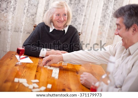 Couple playing dominoes in living room smiling
