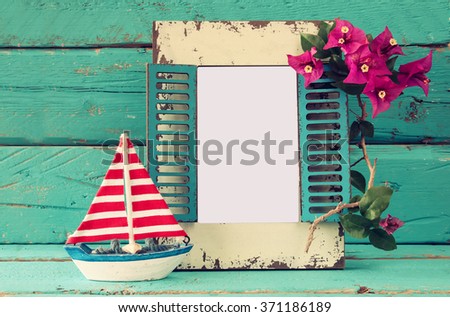 vintage blank frame, sailboat next to beautiful purple mediterranean summer flowers. vintage filtered image. template, ready to put photography 
