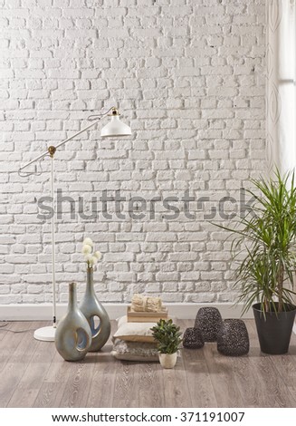 Empty white brick wall with wooden floor and flower
