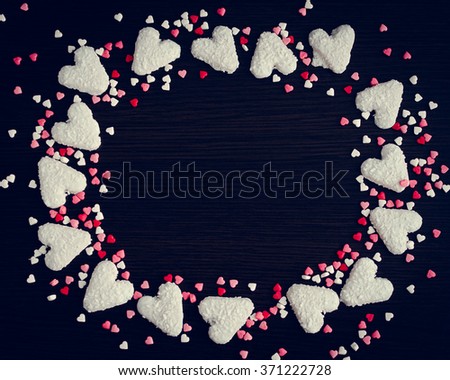 Lot of hearts different colors on the dark wooden background. Empty space for text or photo. Picture frame. Valentines Day background. Valentine's Day theme.