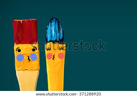 Two colored brushes with smile hold a hearth and kissing. Brushes have two blue hair and cheeks.