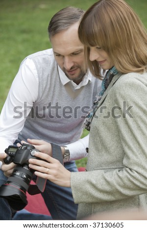 couple with a photo camera checking pictures