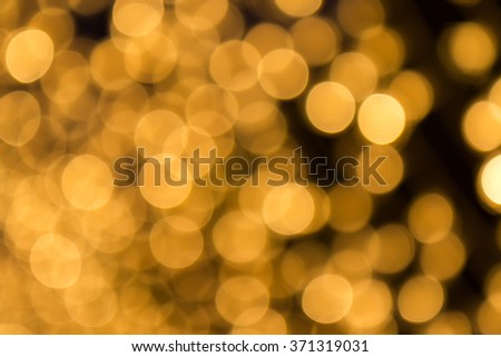 Abstract light celebration blur background with defocused, golden lights.