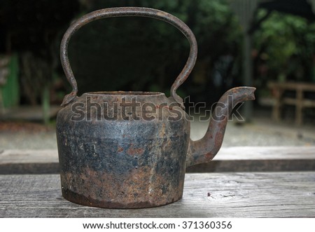 old steel teapot on a old wooden table