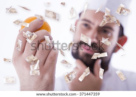 Chef with an orange and money in hand

