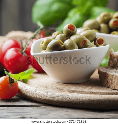 Spanish olives on the wooden table, selective focus and square image