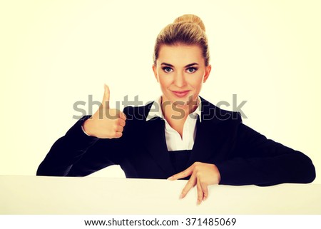 Happy businesswoman holding empty billboard