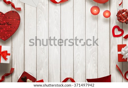 Love scene with free space for text on wooden table with gifts, hearts, decorations